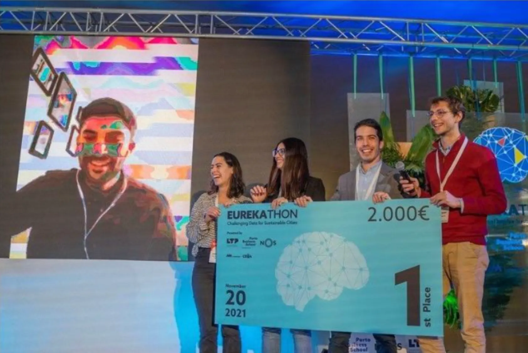 The team on stage at Eurekathon 2021, holding an oversized first-place cheque.