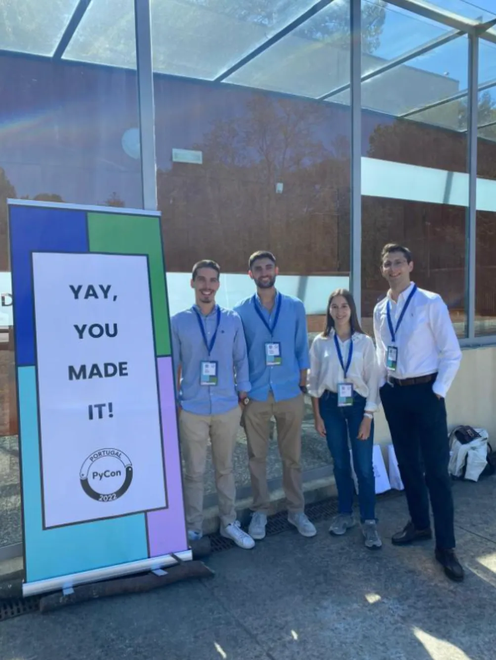 Four members of the Holin team standing beside a PyCon Portugal 2022 banner reading “Yay, you made it!”.